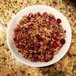  Light brown, wild rice salad with green kiwi and red grapes in a white bowl